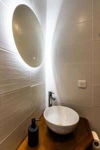 bagno con lavandino bianco e specchio di La Longère Forézienne a Sainte-Agathe-la-Bouteresse