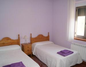 een slaapkamer met 2 bedden en een raam bij Casa Rural Rinconada in La Rinconada de la Sierra