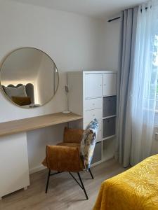 - une chambre avec un miroir, une chaise et un lit dans l'établissement Apartment- La Mia, à Castrop-Rauxel