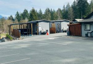a parking lot with three garages in a parking lot at Chims Motel in Port Alberni