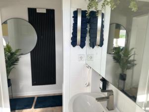 La salle de bains est pourvue d'un lavabo et d'un miroir. dans l'établissement Apartment- La Mia, à Castrop-Rauxel