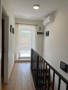 un couloir vide avec un escalier et une fenêtre dans l'établissement The Nook, à Bilice