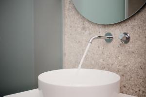 a bathroom with a white sink and a mirror at Levanda apart in Dassia +21 photos