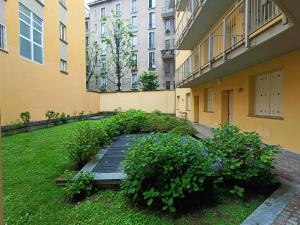 un patio de un edificio de apartamentos con jardín en YR Apartments Milan - Navigli - Pizza&Pasta Apartment, en Milán