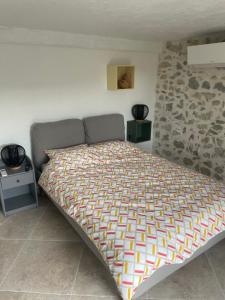 um quarto com uma cama e uma parede de pedra em maison de caractère em Peyroules