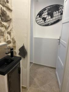 uma casa de banho com um lavatório e uma cesta na parede em maison de caractère em Peyroules