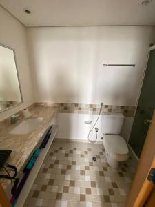 a bathroom with a toilet and a sink at Flat em Alphaville melhor localização in Barueri