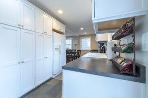 a kitchen with white cabinets and a counter top at Firefly Cottage - close to beach & town! in South Haven