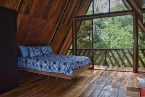 Bett in einem Zimmer mit einem großen Fenster in der Unterkunft Quinta Túru in La Colonia