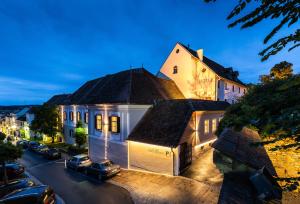 un grande edificio bianco con auto parcheggiate su una strada di Boutique-Hotel Alter Gerichtshof a Hartberg