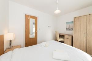 a bedroom with a white bed and a desk at Free Parking Spacious Flat Weekly/Monthly Stay Saving in Reading