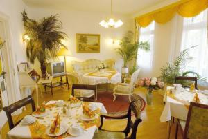 a living room with tables and chairs and a couch at Hotel Victoria in Bad Harzburg