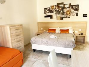 1 dormitorio con 1 cama y 1 silla naranja en Resort Park Village, en Rossano