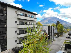 a view of a building with a mountain in the background at The Freshwater in Niseko