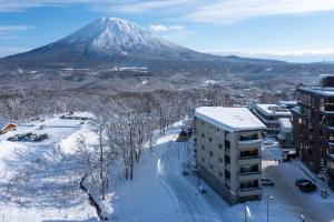 a snow covered mountain in the distance with a building at The Freshwater in Kutchan +51 photos