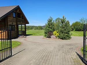 einen Ziegelsteinweg, der zu einem Haus mit einem Pavillon führt in der Unterkunft Holiday House & Sauna in Druskininkai in Neravai