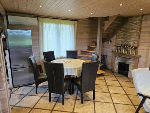 Holiday House & Sauna in Druskininkai في Neravai: غرفة طعام مع طاولة وكراسي وثلاجة