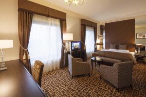 千葉市にあるオークラ千葉ホテルのベッド、テーブル、椅子が備わるホテルルームです。