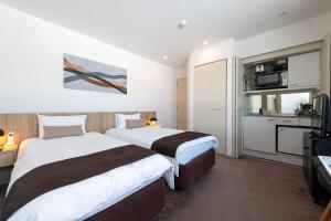 a hotel room with two beds and a television at The Freshwater in Kutchan