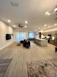 sala de estar amplia con sofá y cocina en Smart Home Sarasota Family Getaway, en Osprey