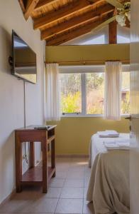 a room with two beds and a table and a window at Cabañas Mellmell in Mar de las Pampas