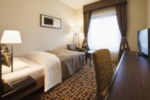 a hotel room with a bed and a desk at Okura Chiba Hotel in Chiba