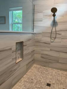 baño con ducha con una foto en la pared en Smart Home Sarasota Family Getaway, en Osprey
