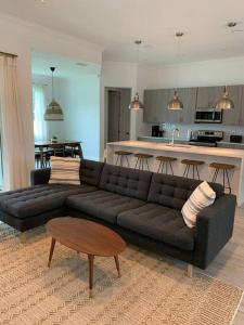 sala de estar con sofá negro y cocina en Smart Home Sarasota Family Getaway, en Osprey
