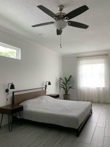 1 dormitorio con 1 cama y ventilador de techo en Smart Home Sarasota Family Getaway, en Osprey