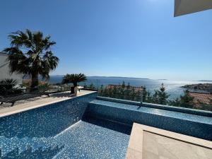 a swimming pool with a view of the ocean at Villa Night Pearl in Trogir
