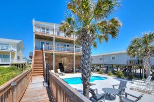 een huis met een zwembad en een palmboom bij Big Tuna in Oak Island