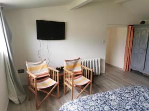 1 dormitorio con 2 sillas y TV en la pared en Bouvet Vincent, en Saint-Cyr-en-Val