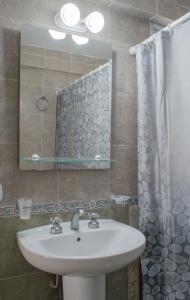 uma casa de banho com um lavatório e um espelho em Cabañas Mellmell em Mar de las Pampas