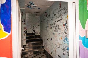 a hallway with graffiti on the walls and stairs at Hostel Backpackers in Mostar