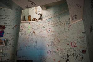 una pared cubierta por escrito y dibujos en una pared en Hostel Backpackers, en Mostar