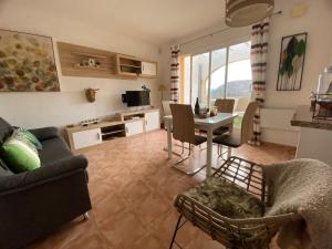 - un salon avec un canapé et une table avec des chaises dans l'établissement Apartment Casa Lieja - Cumbre del Sol, à Cumbre del Sol
