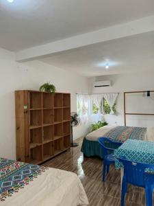 a bedroom with two beds and a table and chairs at Casa Mamá Lolis in Puerto Ángel