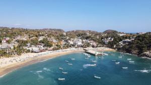 an aerial view of a beach with boats in the water at Casa Mamá Lolis in Puerto Ángel
