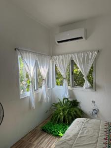 a bedroom with a bed and two windows at Casa Mamá Lolis in Puerto Ángel