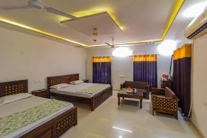 1 dormitorio con 2 camas, sofá y mesa en Jawai Dam Stay, en Bīsalpur