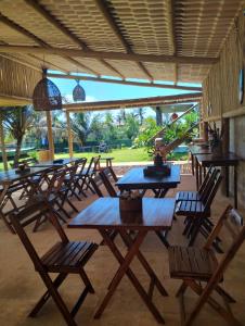 a group of tables and chairs under a pavilion at Nascer do Sol Kitesurf House in Fortim +48 photos