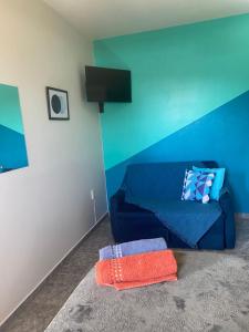 a blue couch in a room with a blue wall at Apartamento cachoeira in Florianópolis