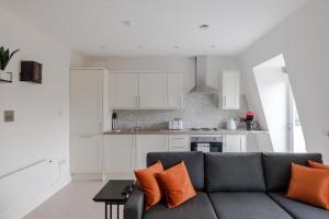 een woonkamer met een bank en een keuken bij Soul in the City - Fitzrovia - By frankie Says in Londen