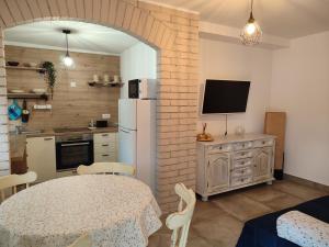 a kitchen with a table and a television in a room at Apartman Noemi in Jadranovo