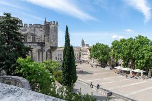 ein Stadtplatz mit einem Schloss im Hintergrund in der Unterkunft Logement de charme en plein coeur d'Avignon in Avignon