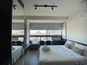 a bedroom with two beds and a large window at Studio Oscar Freire, linda vista de SP!1716 in Sao Paulo +14 photos