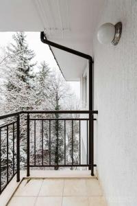 einen Balkon mit einem schwarzen Geländer und einem Fenster in der Unterkunft Apartment in Boyana in Sofia