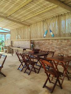 un grupo de mesas y sillas de madera en una habitación en Nascer do Sol en Fortim