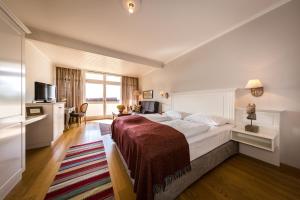 una camera d'albergo con un letto grande e una finestra di Boutique-Hotel Alter Gerichtshof a Hartberg