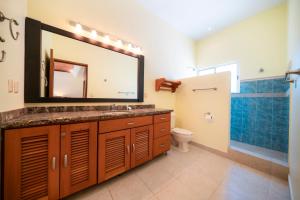 a bathroom with a sink and a toilet and a mirror at Villa Pura Vida - Spacious Oceanview with private pool - At Playacar Phase I in Playa del Carmen